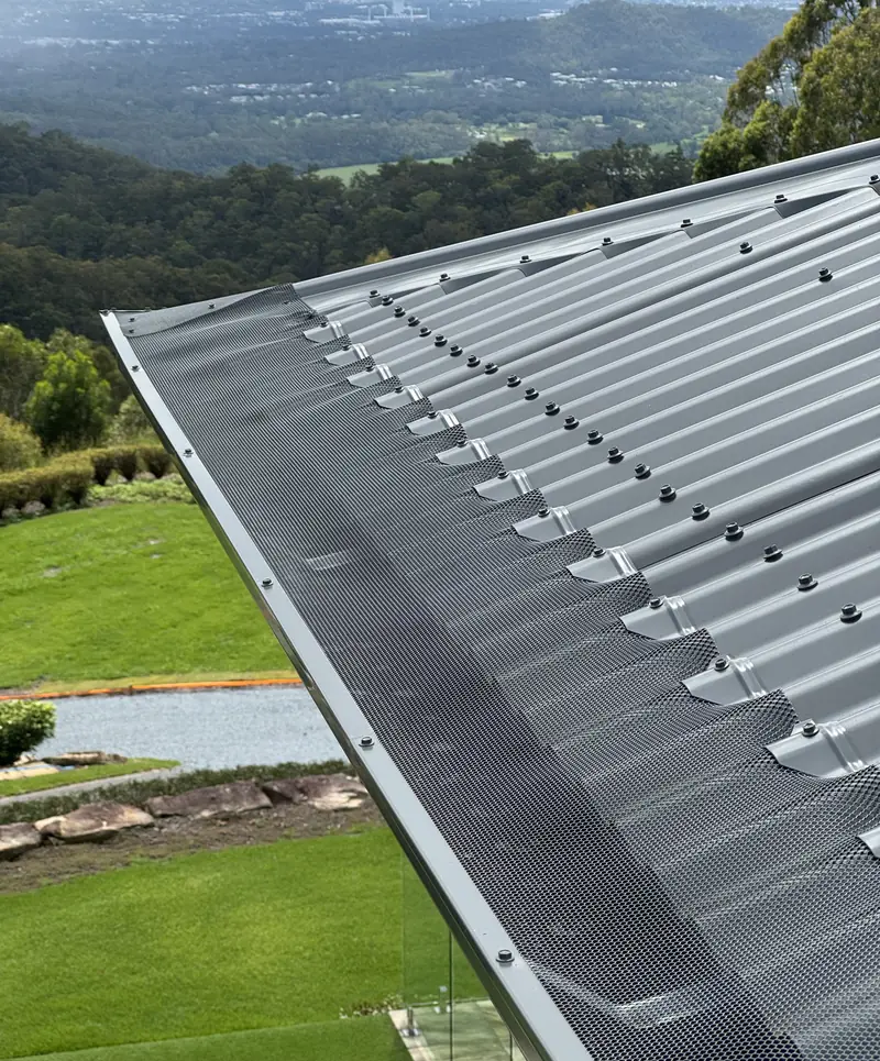 Mesh on a corrugated roof with a hilltop valley view behind