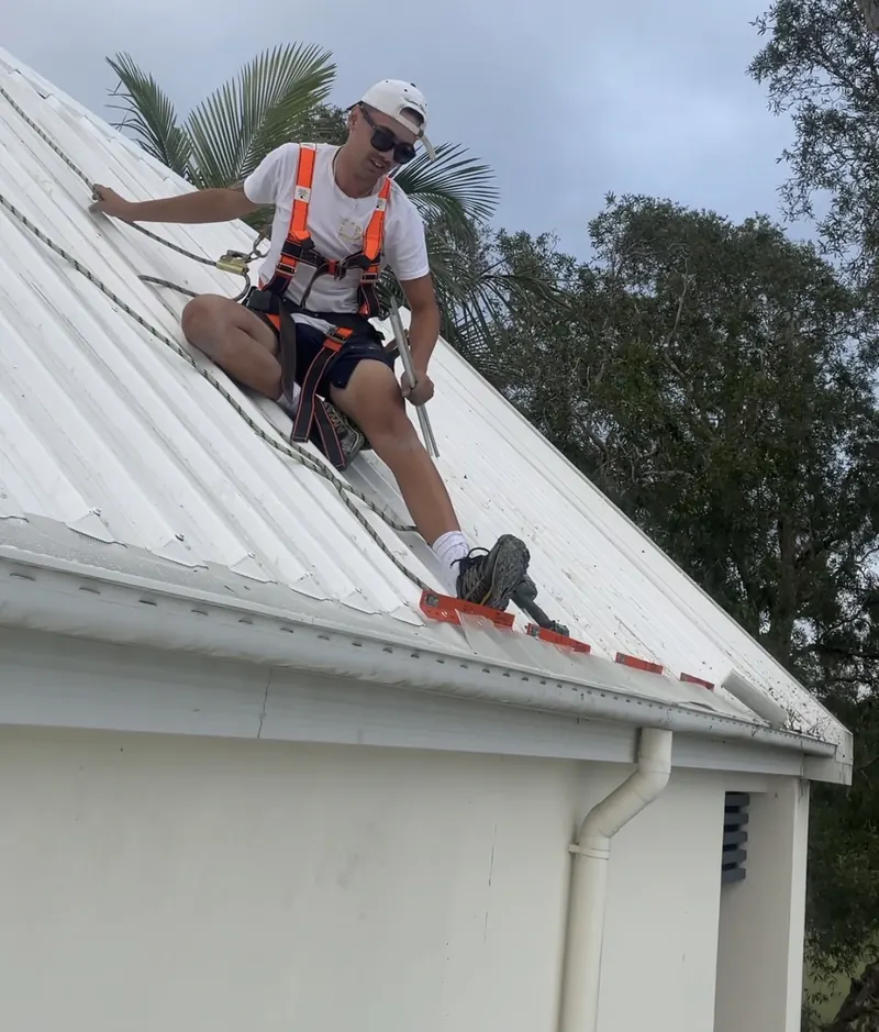 A Working-at-Heights certified My Gutter Guards installer fitting mesh on a roof